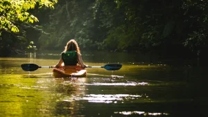 a woman using a kayak in a river