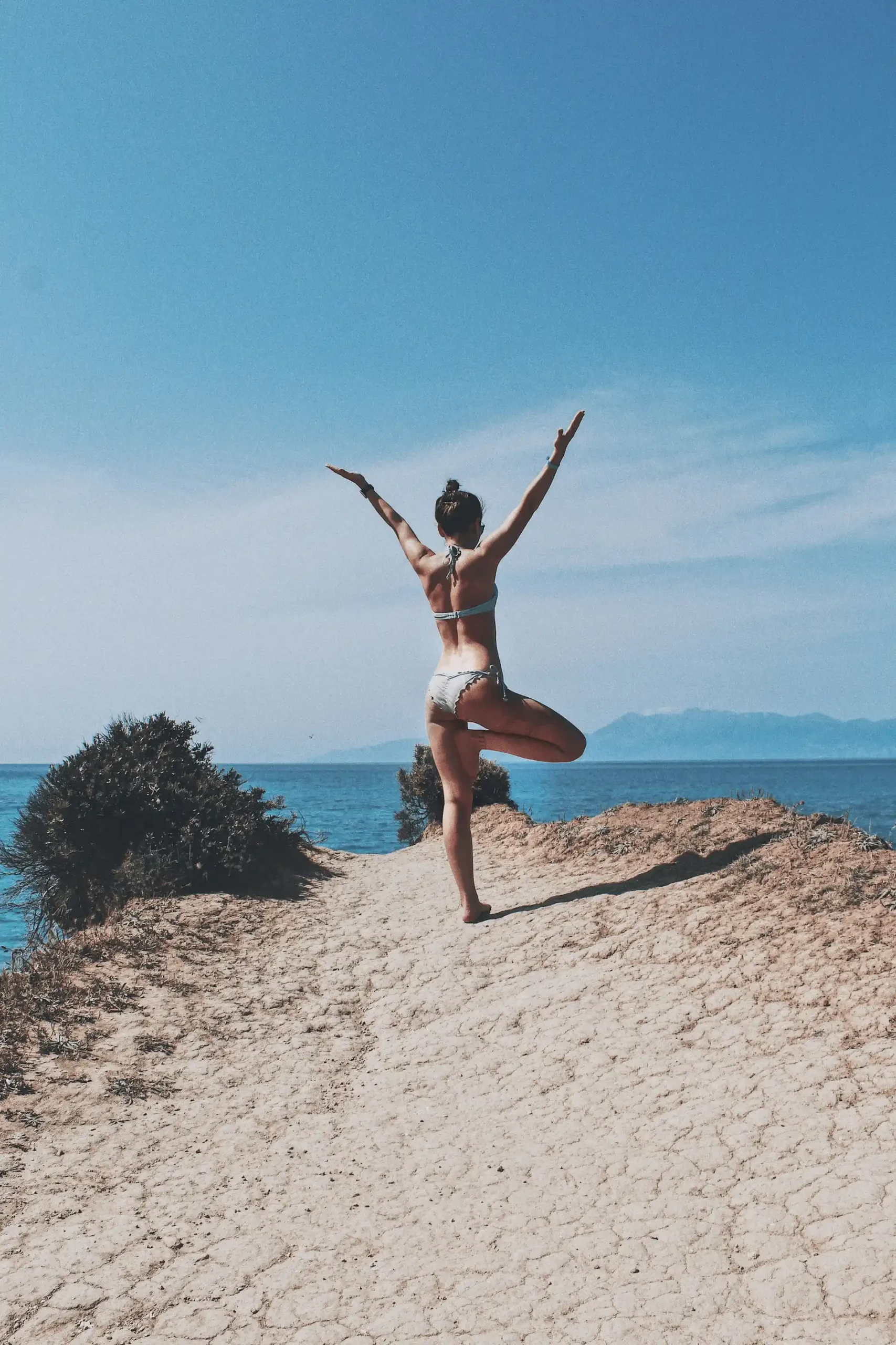 woman doing yoga pose at the beach